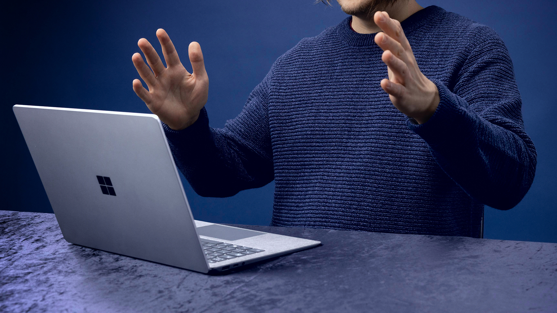 Person and laptop in blue background